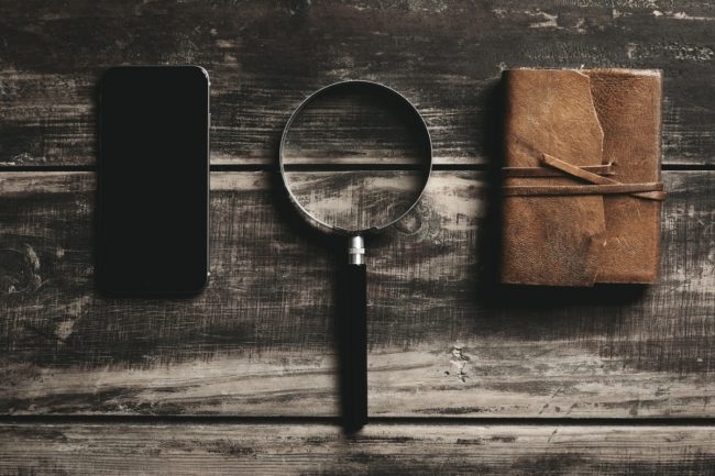 Optimized-Optimized-mobile-smartphone-magnifier-notebook-with-leather-cover-isolated-black-farm-wooden-table-mysterious-detective-game-concept (1) Aplicaciones móviles y juegos de escape room