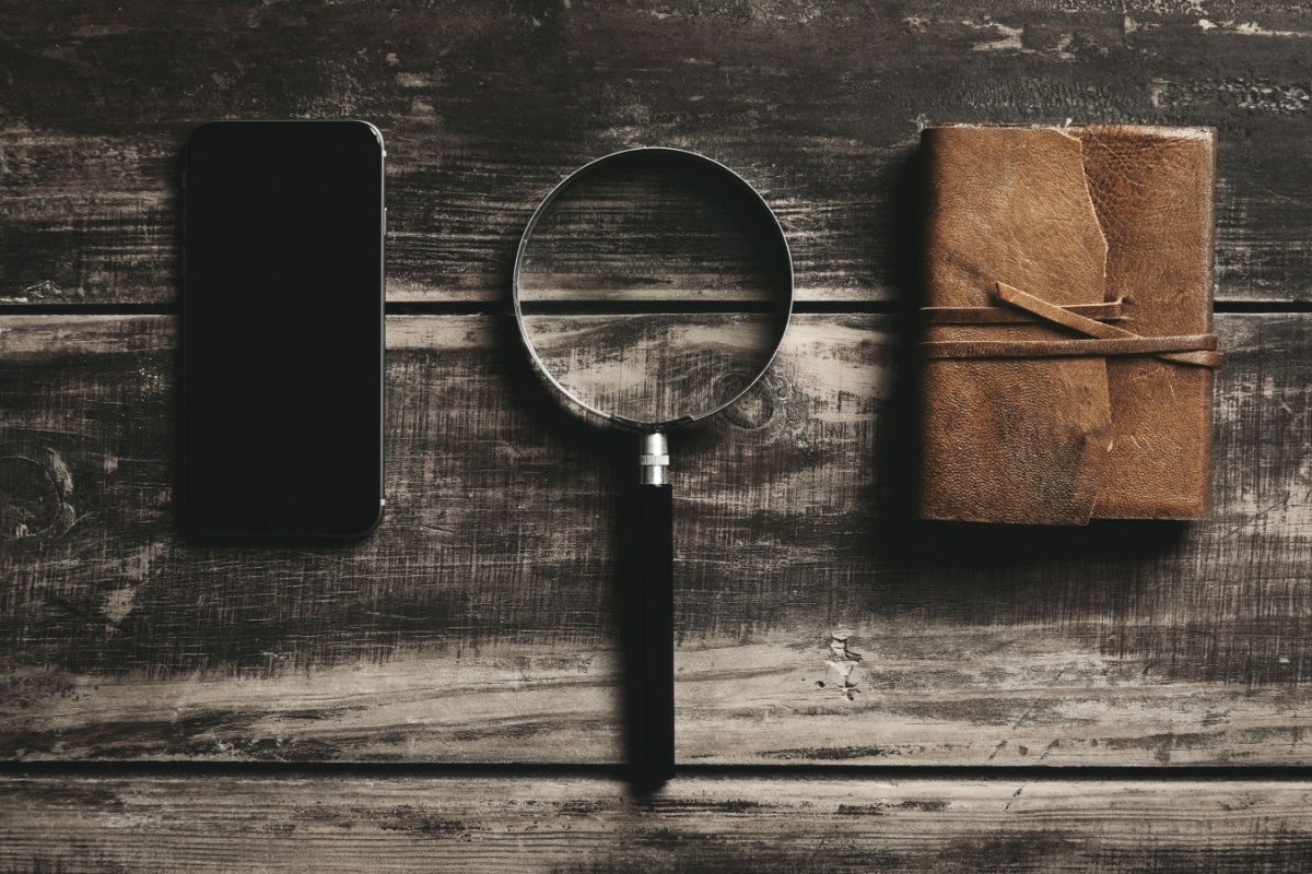 Optimized-Optimized-mobile-smartphone-magnifier-notebook-with-leather-cover-isolated-black-farm-wooden-table-mysterious-detective-game-concept (1) Aplicaciones móviles y juegos de escape room